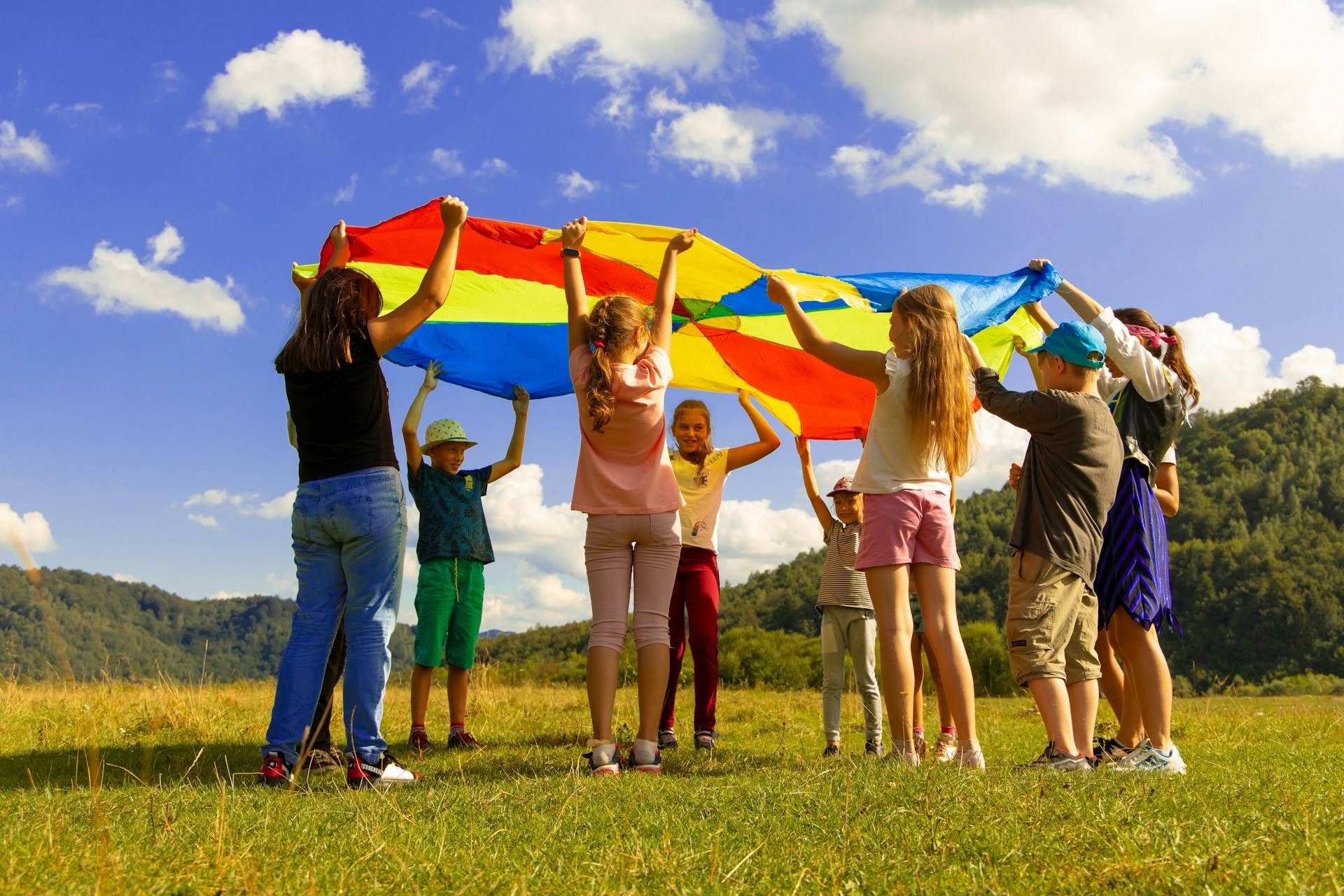 eine Gruppe Kinder steht im Kreis mit einem bunten Tuch